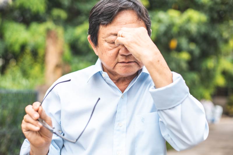 Elder man holding nose with sinus pressure